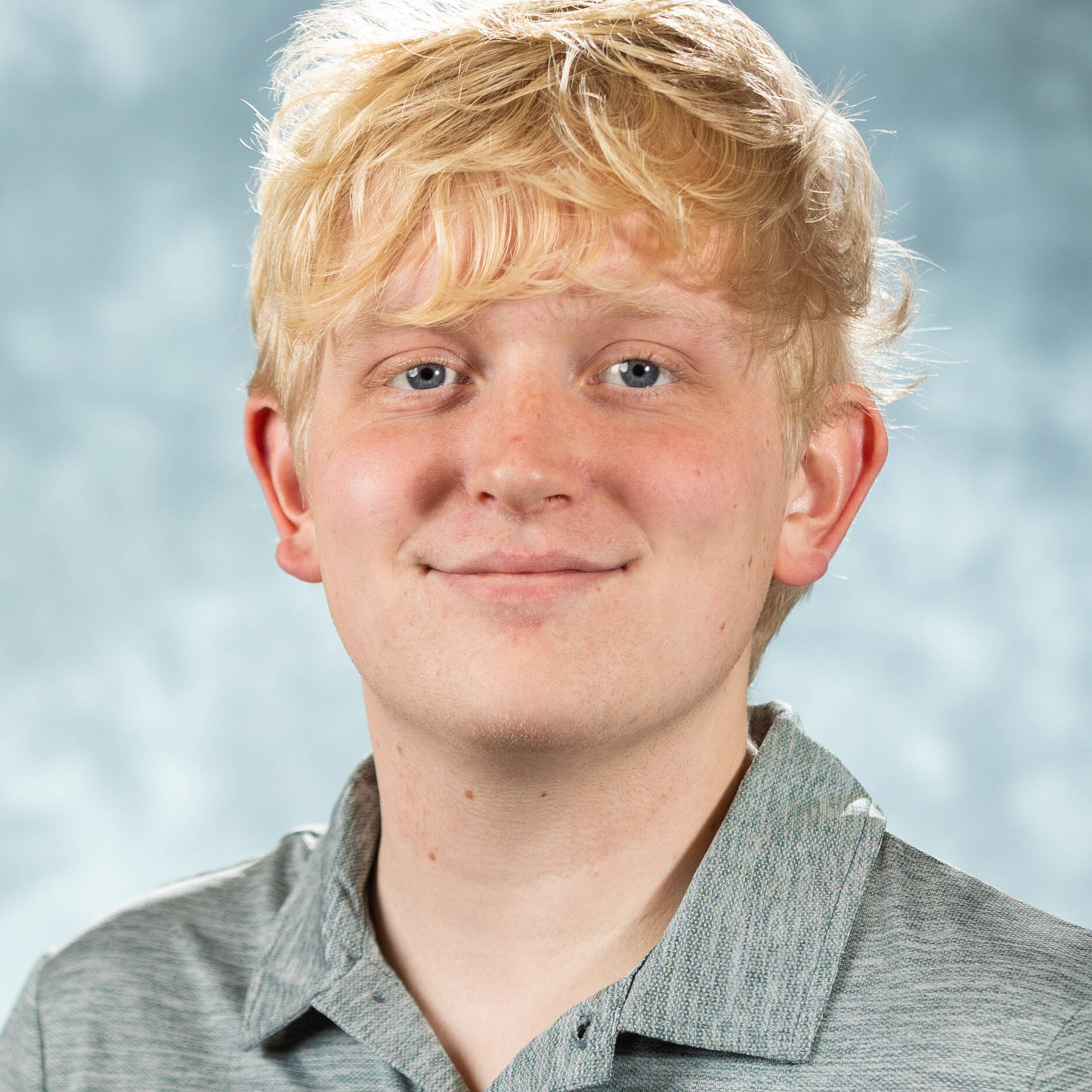 Smiling blond man against a decorative background